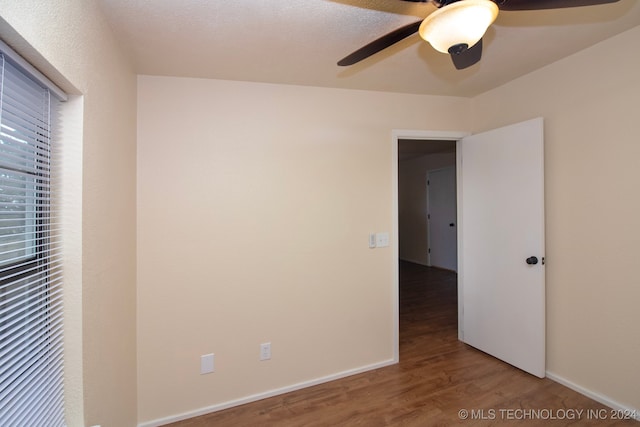 unfurnished bedroom with ceiling fan and wood-type flooring