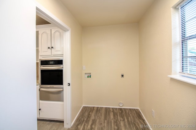 clothes washing area featuring hardwood / wood-style flooring, electric dryer hookup, washer hookup, and a wealth of natural light