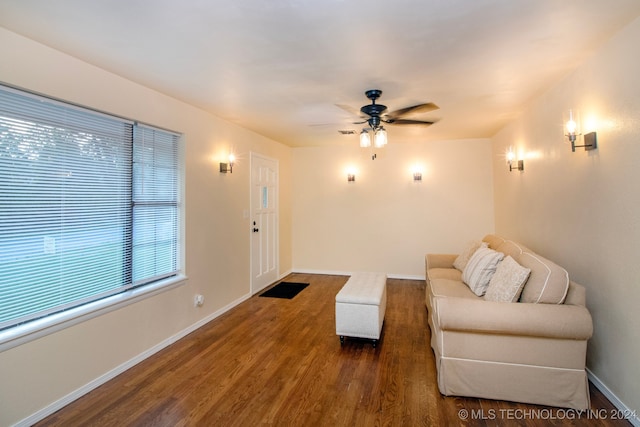 living room featuring dark wood-type flooring and ceiling fan