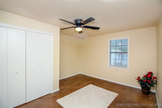 unfurnished bedroom featuring dark carpet, a closet, and ceiling fan