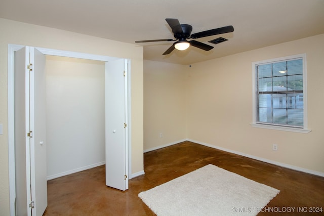 unfurnished bedroom with dark carpet, a closet, and ceiling fan