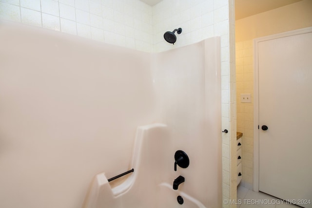full bath featuring washtub / shower combination and tile patterned floors