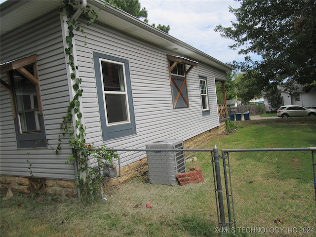 view of side of property with a lawn and central air condition unit