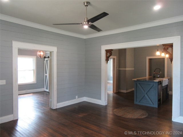 empty room with ceiling fan, dark hardwood / wood-style floors, sink, and crown molding