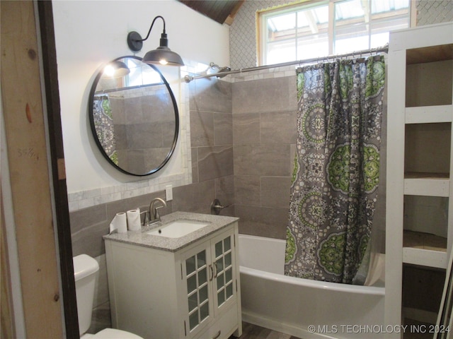 full bathroom with vanity, shower / bath combo with shower curtain, and toilet