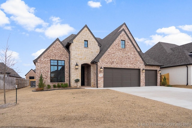 5424 E 125th Pl S, Bixby, OK 74008 - view of front of house featuring fence, driveway, brick siding, an attached garage, and stone siding