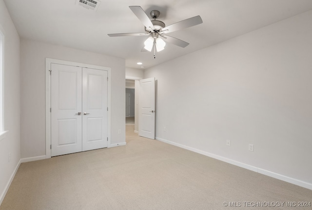 unfurnished bedroom with a closet, ceiling fan, and light carpet