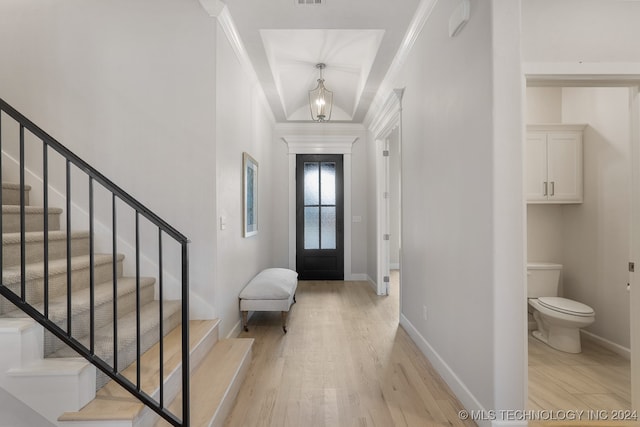 foyer featuring ornamental molding and light wood-type flooring