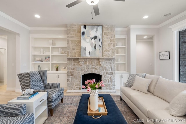 5424 E 125th Pl S, Bixby, OK 74008 - living area featuring a ceiling fan, wood finished floors, built in shelves, crown molding, and a stone fireplace