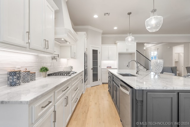 kitchen with sink, white cabinetry, light hardwood / wood-style flooring, and premium range hood