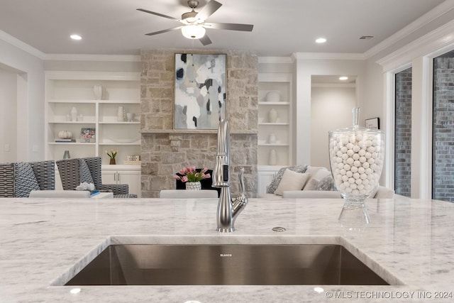 5424 E 125th Pl S, Bixby, OK 74008 - kitchen with ornamental molding, light stone counters, a sink, a ceiling fan, and built in shelves