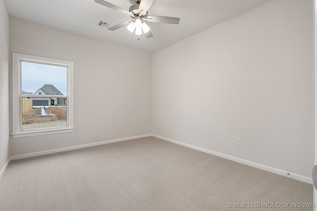 carpeted spare room with ceiling fan