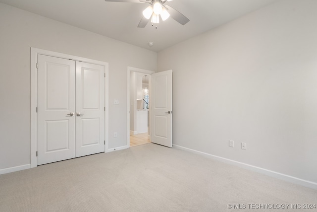 unfurnished bedroom with a closet, ceiling fan, and light carpet