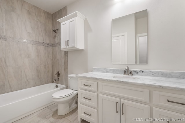 full bathroom with tile patterned floors, vanity, tiled shower / bath combo, and toilet