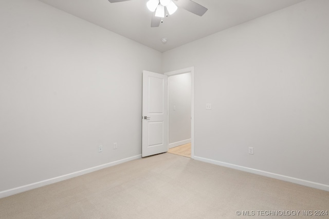 spare room featuring ceiling fan and light carpet