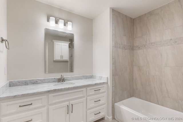 bathroom with tiled shower / bath and vanity