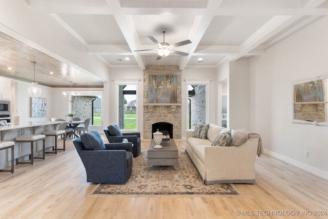 living room with coffered ceiling, beamed ceiling, light wood-type flooring, a fireplace, and ceiling fan