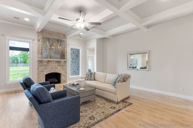 living room with light hardwood / wood-style flooring, beam ceiling, coffered ceiling, a fireplace, and ceiling fan