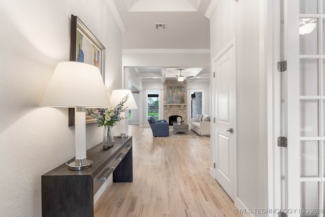 hall with light hardwood / wood-style flooring, crown molding, beam ceiling, and coffered ceiling