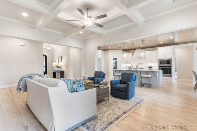 living room featuring ceiling fan, coffered ceiling, beam ceiling, light hardwood / wood-style floors, and sink