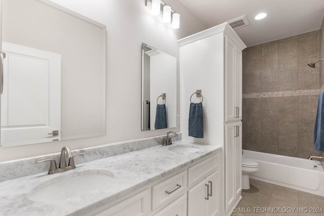 full bathroom featuring tile patterned flooring, toilet, tiled shower / bath combo, and double sink vanity