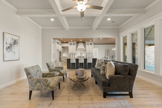 living room featuring ceiling fan, coffered ceiling, plenty of natural light, and light wood-type flooring