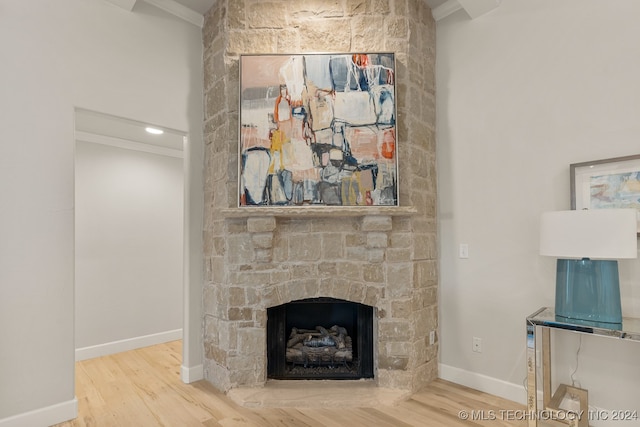 unfurnished living room with a stone fireplace and wood-type flooring