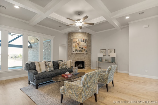 living room with ceiling fan, coffered ceiling, light hardwood / wood-style floors, a fireplace, and beamed ceiling