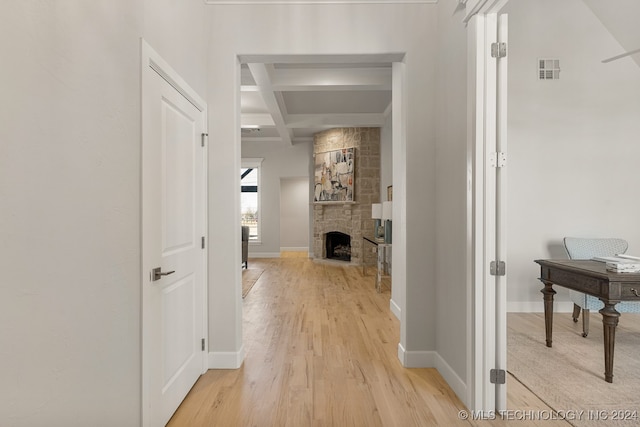 hallway featuring light hardwood / wood-style floors, beamed ceiling, and coffered ceiling