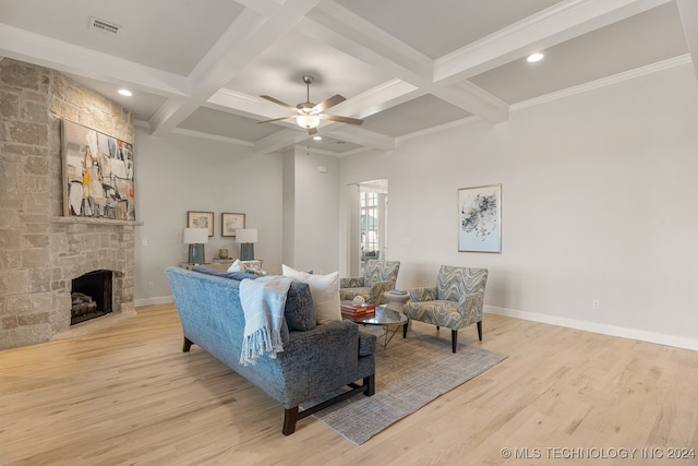 living room featuring a fireplace, ceiling fan, light hardwood / wood-style floors, and coffered ceiling