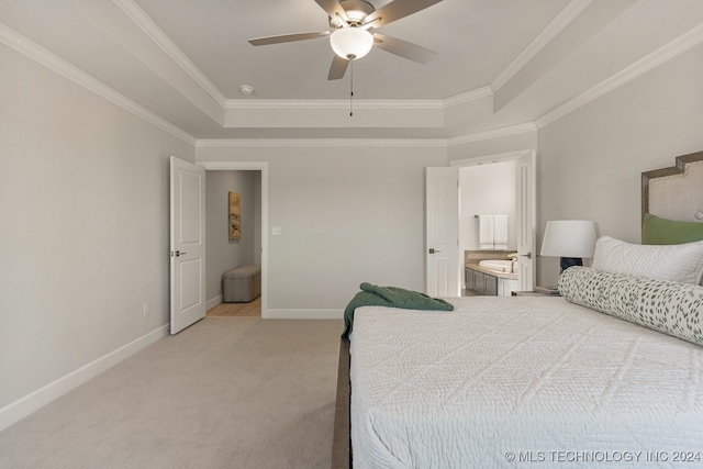 carpeted bedroom featuring ceiling fan, crown molding, ensuite bathroom, and a tray ceiling