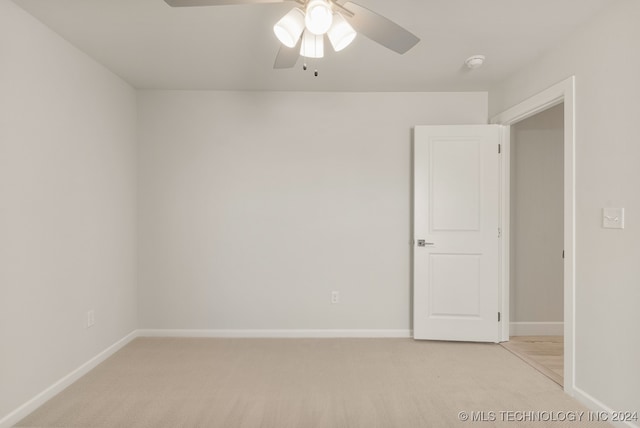 carpeted spare room featuring ceiling fan