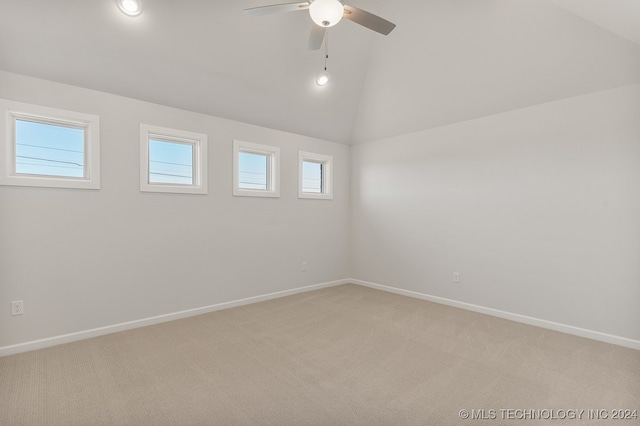 carpeted spare room featuring ceiling fan and vaulted ceiling