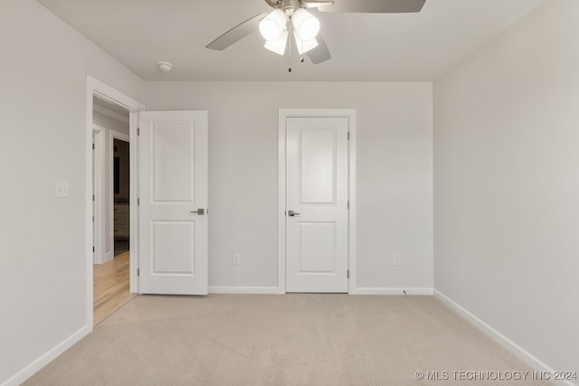 unfurnished bedroom featuring ceiling fan and light colored carpet