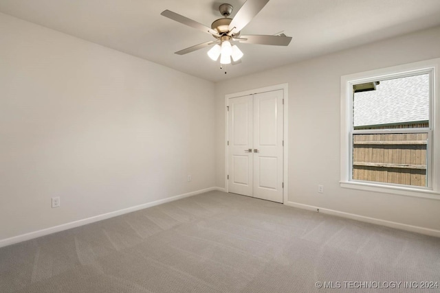 unfurnished room featuring light colored carpet, baseboards, and a ceiling fan