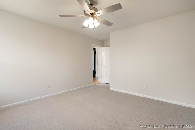 spare room featuring light colored carpet and ceiling fan