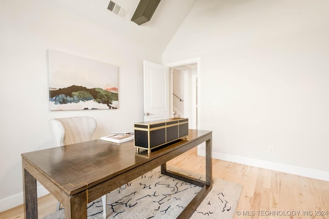 office area featuring wood finished floors, vaulted ceiling, and baseboards