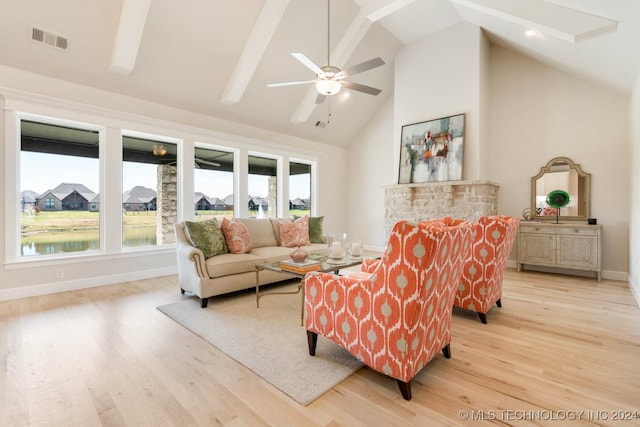 living room with a water view, light wood-type flooring, high vaulted ceiling, and ceiling fan