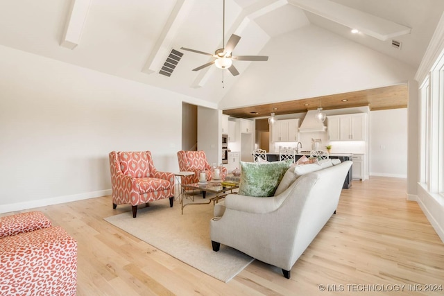 living room featuring light wood-style flooring, ceiling fan, high vaulted ceiling, and baseboards