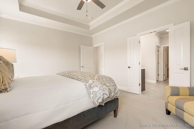 bedroom featuring ornamental molding, a tray ceiling, light carpet, ceiling fan, and baseboards