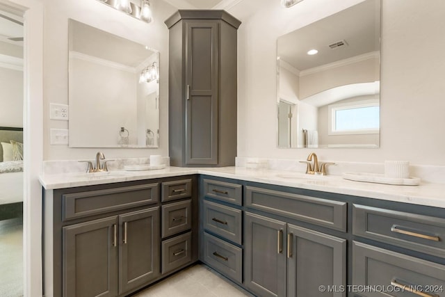 ensuite bathroom with crown molding, double vanity, and tile patterned floors