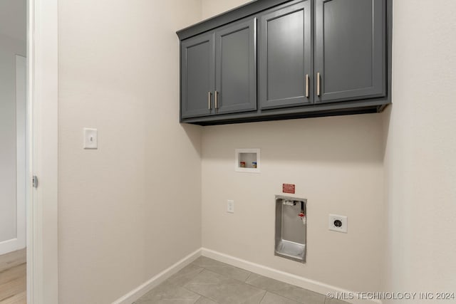 laundry room featuring hookup for a washing machine, electric dryer hookup, and cabinets