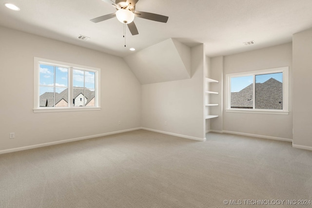 bonus room with carpet flooring, plenty of natural light, and ceiling fan