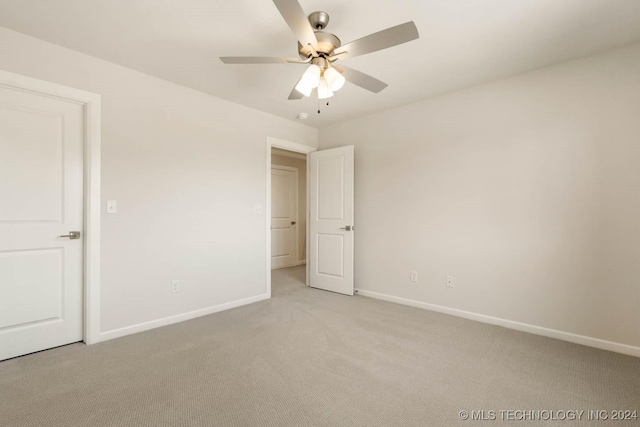 unfurnished bedroom featuring light colored carpet, baseboards, and a ceiling fan