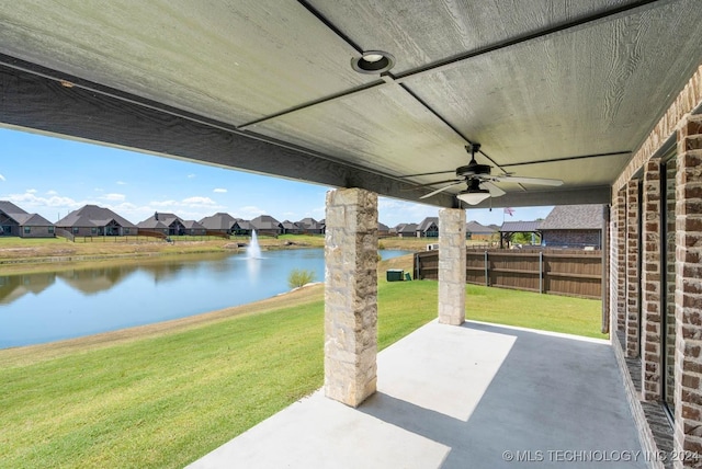 view of patio with a water view, ceiling fan, and a residential view