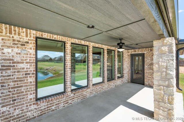 view of patio / terrace featuring a ceiling fan and a water view