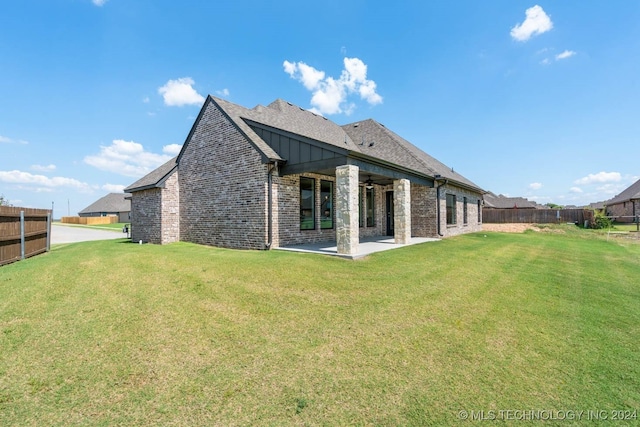 rear view of house featuring a ceiling fan, a patio area, and brick siding