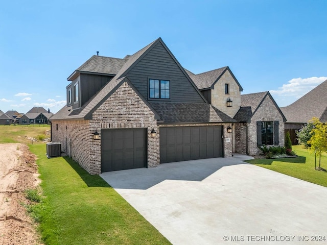 french country style house with a garage, driveway, a front yard, and roof with shingles