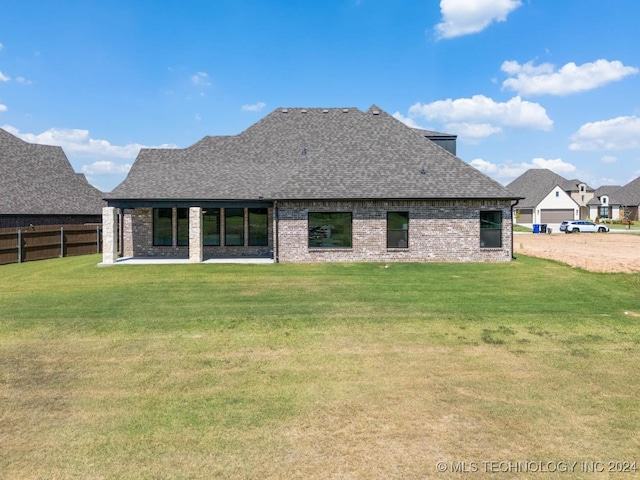 back of property featuring a shingled roof, brick siding, and a patio area