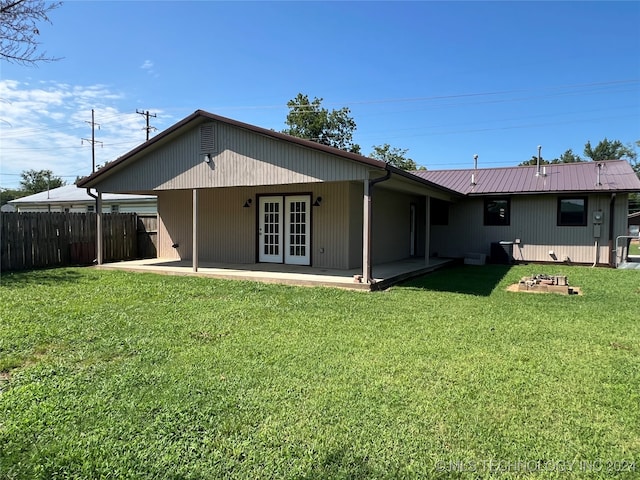 back of house featuring french doors and a lawn